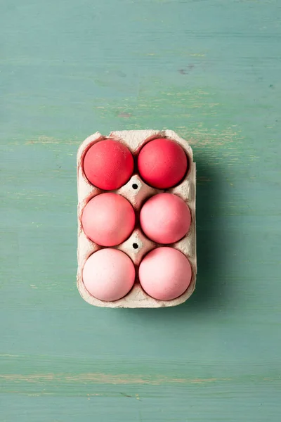 Vista superior de huevos de Pascua pintados en soporte de cartón sobre superficie texturizada - foto de stock