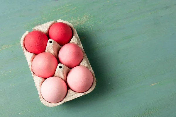 Vue du dessus des œufs de Pâques peints dans un support en carton sur une surface texturée — Photo de stock