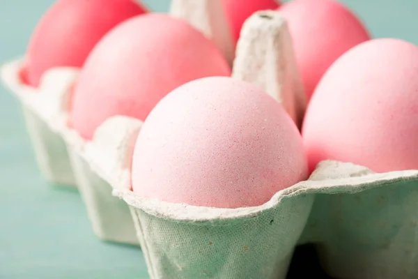 Selective focus of painted easter eggs in carrier on grey — Stock Photo
