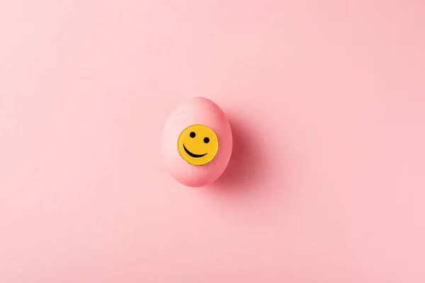 Top view of painted easter egg on pink surface — Stock Photo