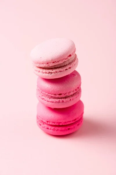 Three colorful tasty macarons with filling on pink — Stock Photo