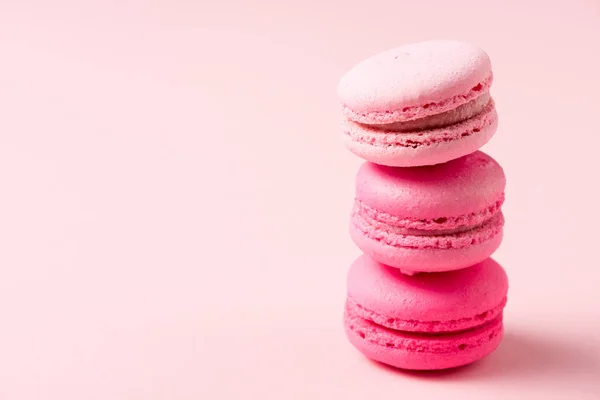 Three colorful tasty macarons with filling on pink — Stock Photo