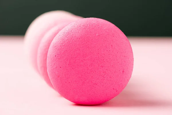 Messa a fuoco selettiva di dolci macaron colorati sulla superficie rosa — Foto stock