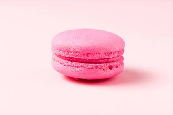 Bright macaron cookie with filling on pink surface — Stock Photo
