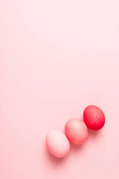 Top view of colorful painted easter eggs on pink surface — Stock Photo