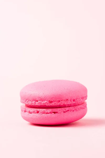 Bright macaron cookie with filling on pink surface — Stock Photo