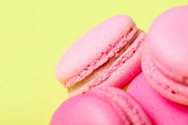 Sabrosos macarrones rosados con relleno en la superficie amarilla - foto de stock