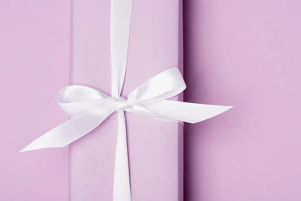 Top view of gift box with boy on purple surface — Stock Photo