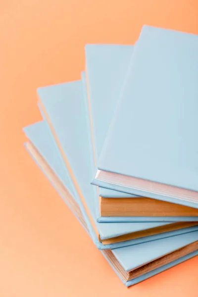 Foyer sélectif de la pile de livres bleus sur la surface orange — Photo de stock