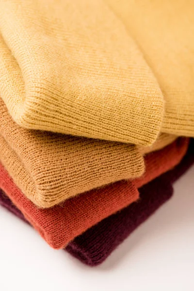 Stapel gefalteter bunter Kleidung auf weißer Oberfläche — Stockfoto