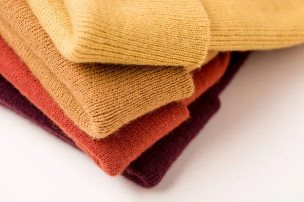 Стек складеного барвистого одягу на білій поверхні — стокове фото