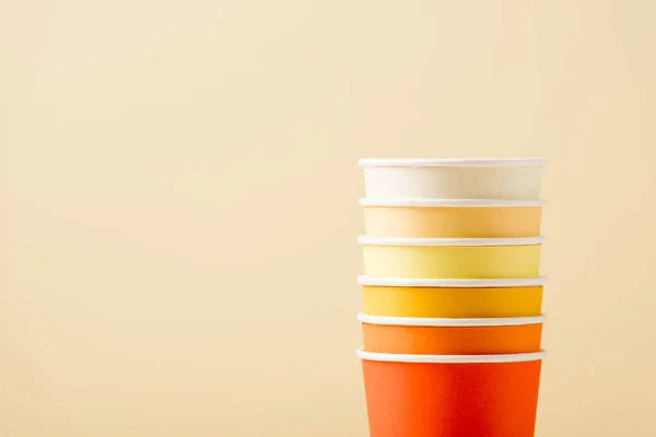 Bright colorful disposable cups isolated on beige background — Stock Photo