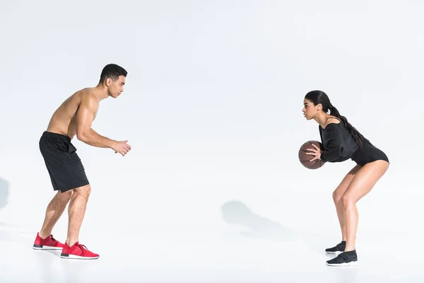 Deportivo multicultural joven hombre y mujer jugando pelota sobre fondo blanco - foto de stock