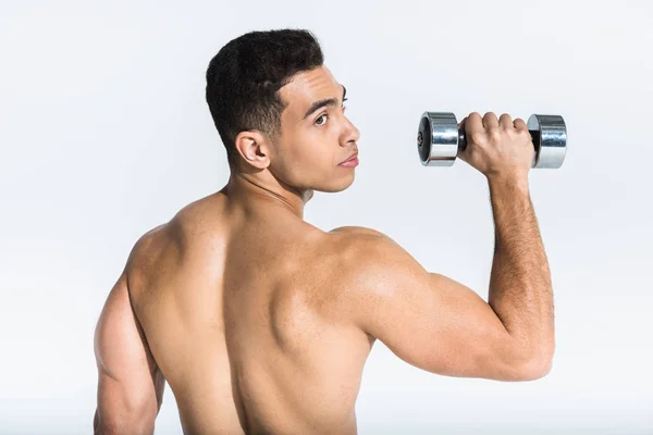 Handsome mixed race man with muscular torso holding dumbbell on white — Stock Photo