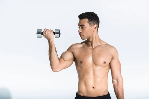 Bonito misto raça homem com muscular torso segurando halteres no branco — Fotografia de Stock