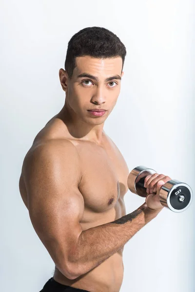 Good-looking athletic mixed race man training with dumbbells and looking at camera on white — Stock Photo