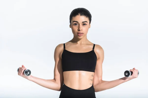 Chica afroamericana bastante deportiva en negro entrenamiento sujetador deportivo con mancuernas en blanco - foto de stock