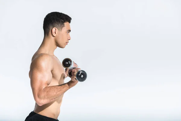 Side view of shirtless mixed race man training with dumbbells on white — Stock Photo