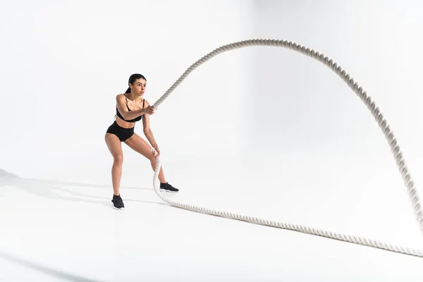 Beautiful athletic african american girl training with white ropes on white — Stock Photo