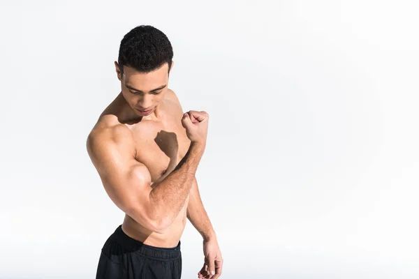 Athletic mixed race man with muscular torso demonstrating biceps on white — Stock Photo