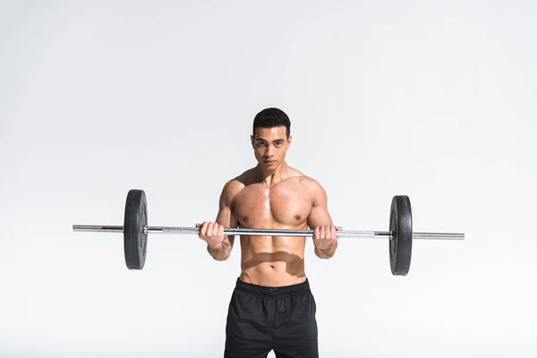 Handsome athletic mixed race with muscular torso training with barbell on white — Stock Photo