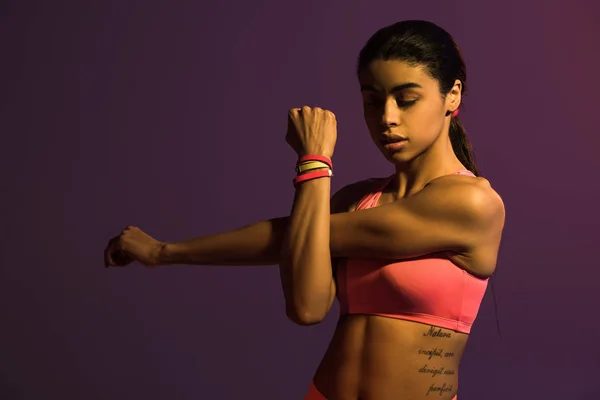 Attractive sportive african american girl warming up isolated on purple — Stock Photo