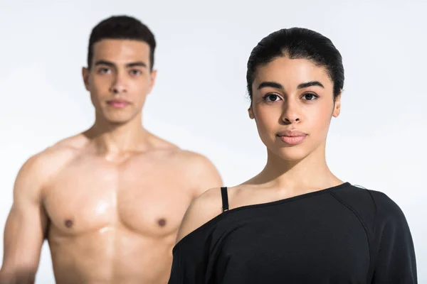 Selective focus of pretty african american girl and shirtless mixed race man on white — Stock Photo