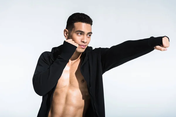 Handsome mixed race man in black sports jacket warming up on white — Stock Photo