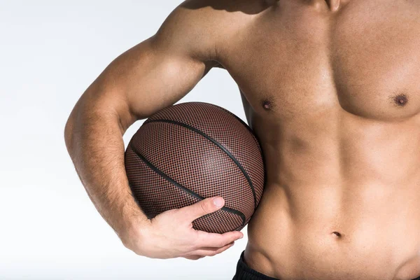 Vista cortada do homem atlético com torso muscular segurando bola marrom no branco — Fotografia de Stock