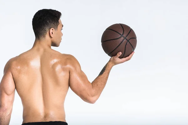 Esportivo misto raça homem com muscular torso segurando bola marrom no branco — Fotografia de Stock