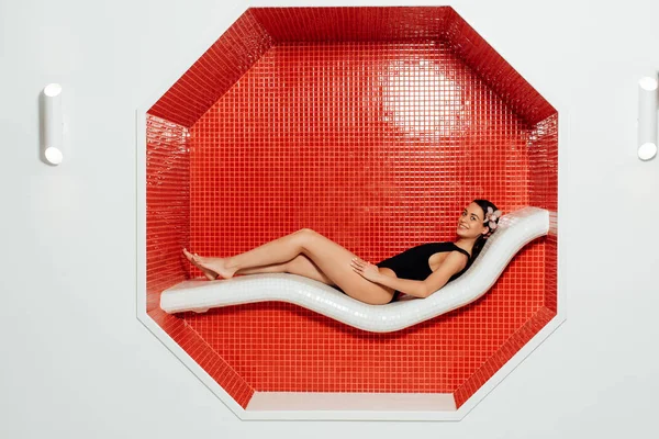 Приваблива молода жінка в купальнику лежить в спа-центрі — стокове фото