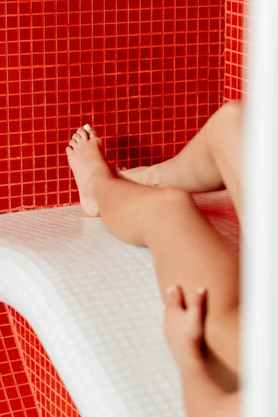 Vue partielle de la jeune femme pieds nus couchée dans le centre de spa — Photo de stock