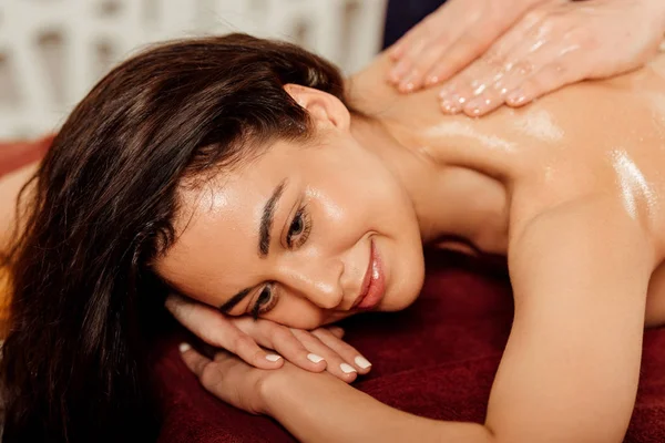 Sorrindo jovem mulher desfrutando de massagem ayurvédica no centro de spa — Fotografia de Stock