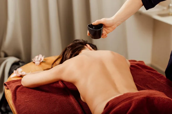 Обрезанный вид массажера, делающего аюрведический массаж в спа-центре — стоковое фото