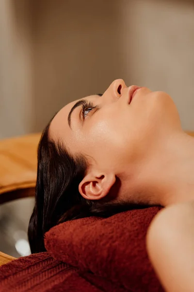 Giovane donna sdraiata sul lettino da massaggio nel centro benessere — Foto stock