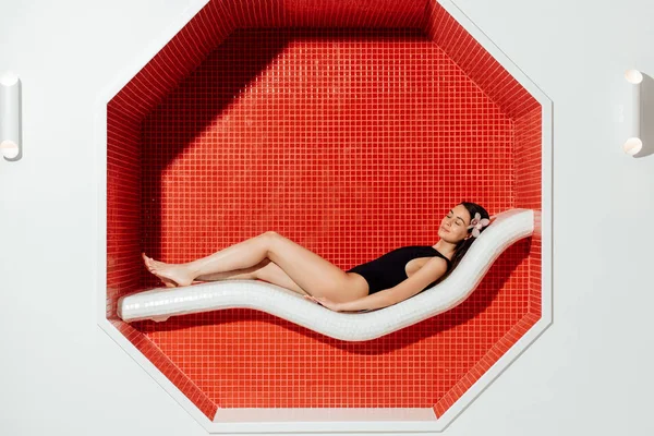 Donna rilassata in costume da bagno sdraiata sul divano nel centro benessere — Foto stock