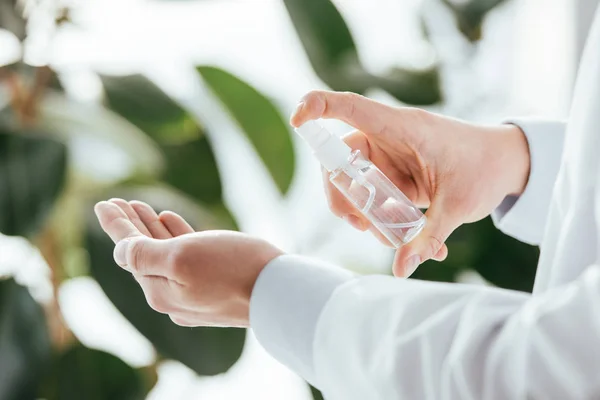 Ausgeschnittene Ansicht eines Arztes, der antibakterielles Spray auf der Hand in der Klinik anwendet — Stockfoto