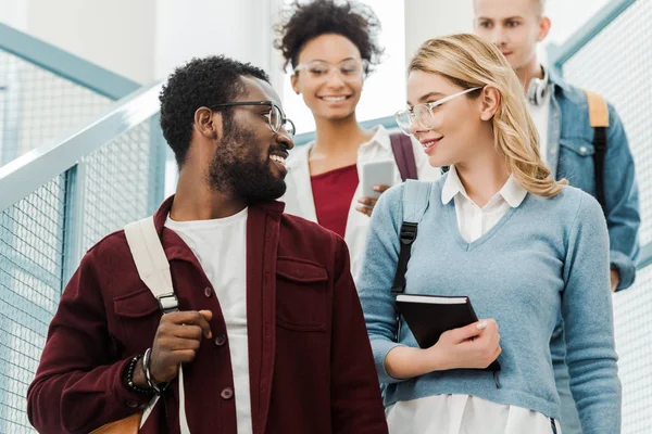 Group of multiethnic students with backpacks in college — Stock Photo