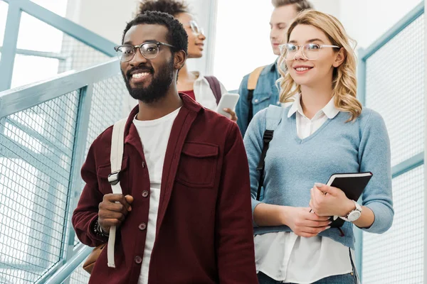 Group of multiethnic students with backpacks in college — Stock Photo