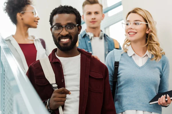 Grupo de estudantes multiétnicos com mochilas na faculdade — Fotografia de Stock