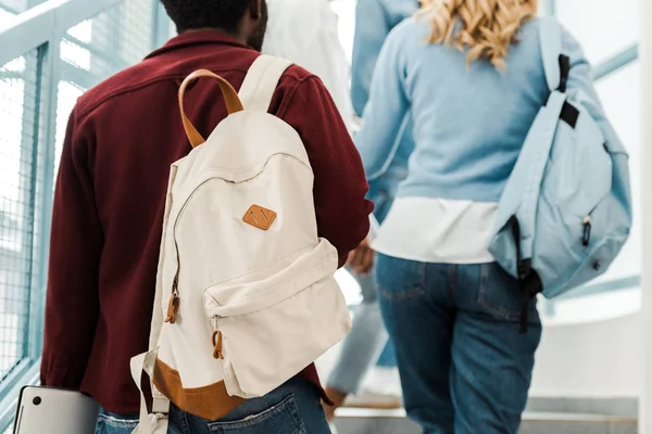 Cropped view of students with backpacks on stairs in university — Stock Photo