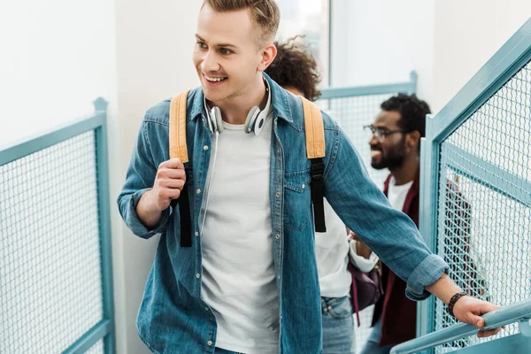 Studenti multietnici sorridenti con zaini sulle scale del college — Foto stock