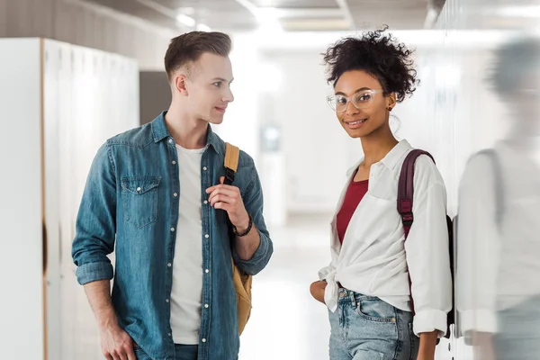 Two multiethnic students standing in corridor in university — Stock Photo