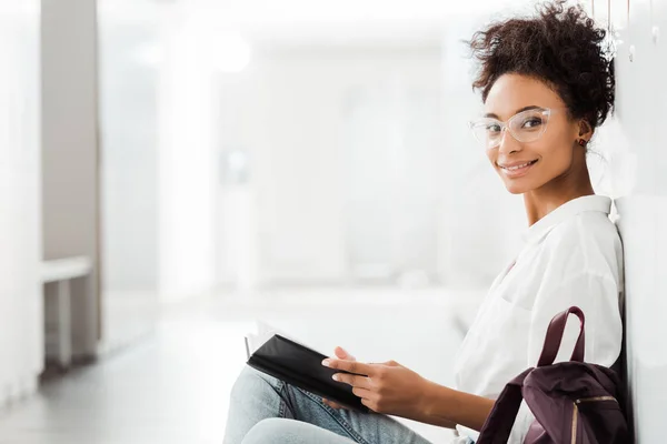 Afrikanisch-amerikanischer Student mit Notizbuch im Flur der Universität — Stockfoto