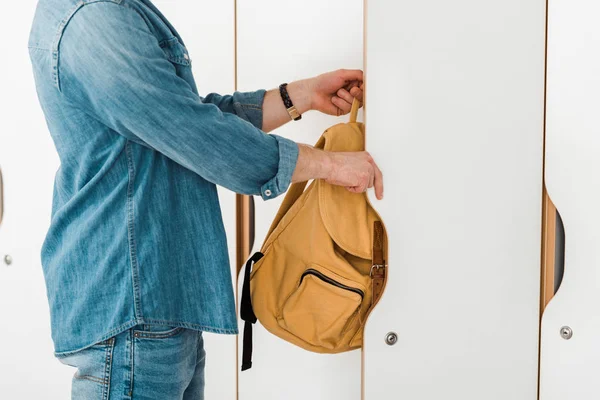 Vista recortada de estudiante con armario de apertura de mochila - foto de stock