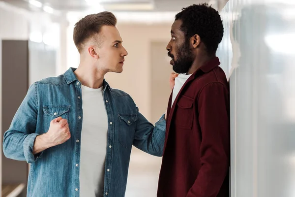 Two multicultural students fighting in corridor in university — Stock Photo