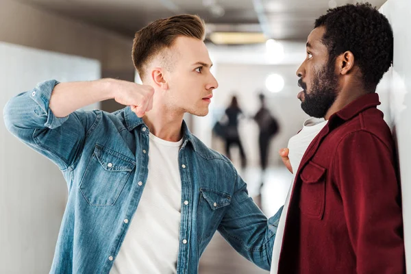 Two multicultural students fighting in corridor in college — Stock Photo