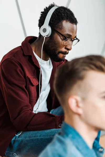 Afrikanisch-amerikanischer Student mit Brille hört Musik über Kopfhörer — Stockfoto