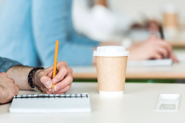 Partial view of students writing during lecture in college — Stock Photo