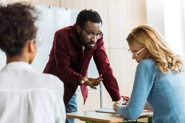 Afro-americano professor de óculos conversando com estudante na universidade — Fotografia de Stock